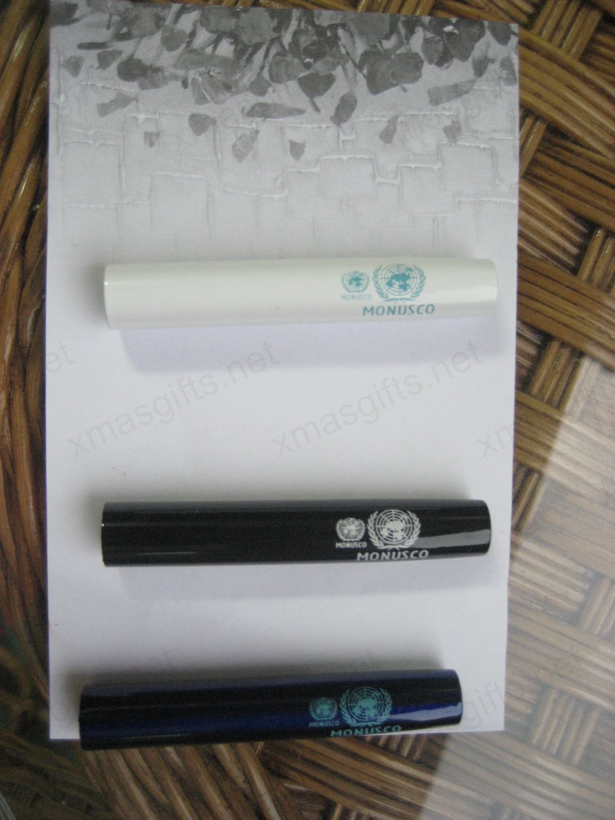 Trois stylos MONUSCO en blanc, noir et bleu foncé