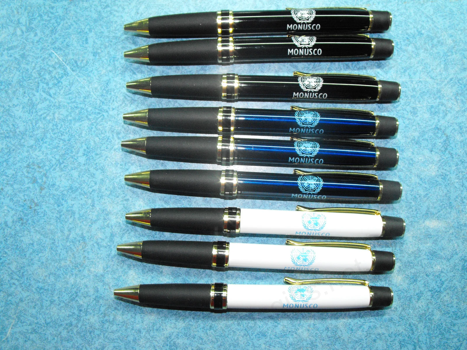 Stylos métalliques de la marque MONUSCO en noir, bleu et blanc