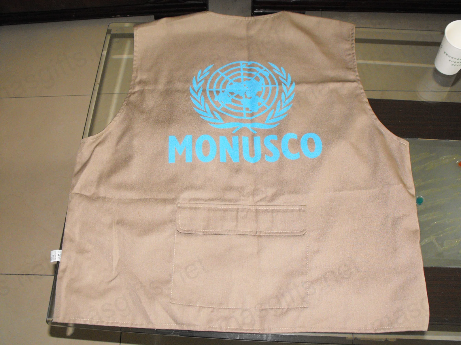 Gilet de reporter kaki arrière avec l’emblème des Nations Unies et le texte MONUSCO.