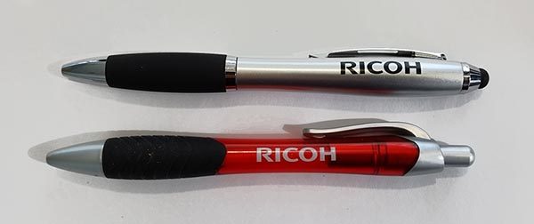 Silberne und rote RICOH-Stifte nebeneinander